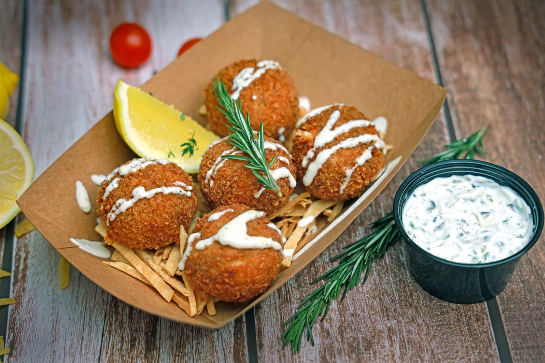 Plated crab cakes with lemon wedges and dipping sauce