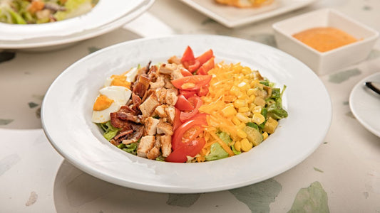 Cobb salad with rows of toppings on a plate